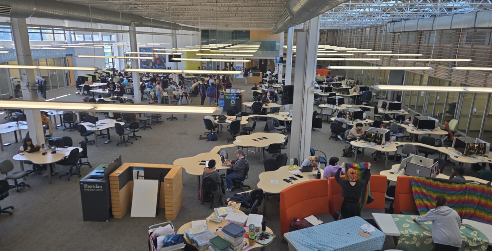 This is the Learning commons at Sheridan. 
      This is where people come to study, get work done, and it is a medium/high level noisy area. 
      This is academic workspace for students at the college. It has an open type of layout with workstations, activity areas and seating for students. 
      In terms of colour, it has neutral colours to provide calmness while providing comforting colours to relax. On a psychological level, it provides people with a sense of community, as everyone is socializing with each other. In terms of the way its built, it provides easy flow, as the center is made to walk from one side to the other, while maintaining space for people to get around to tables and such. 