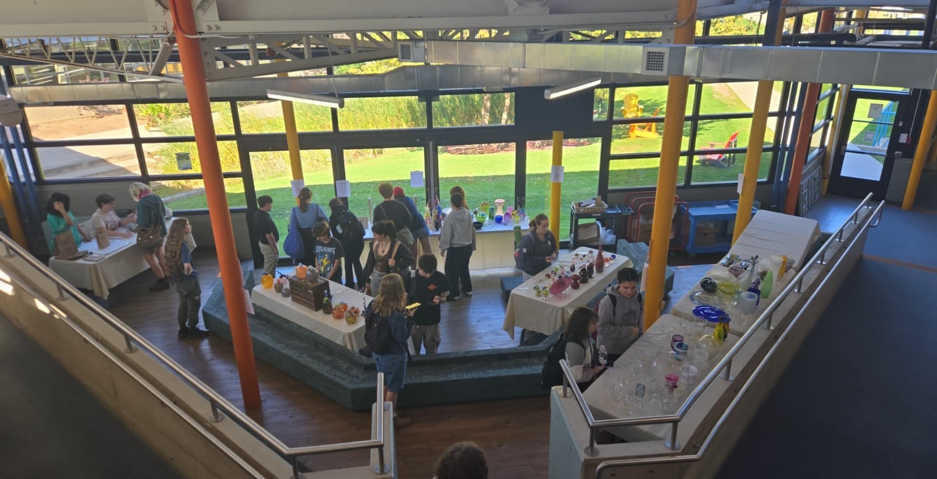This is a seating section located where connects 3 buildings together. This showcases the elevated ramps and a small seating section that has sofa-like seats for students to rest for short periods of time. Due to the high volume of students walking to other buildings, it was architecturally built in a way that students will use it for short periods of time as opposed to long. This is due to the concrete like feeling of the seats. In terms of the structure and colours, this is also a type of industrial structure with colours that provide a warm welcome feeling. With the seating pointing towards the window, student can take a short time to admire the scenery while relaxing for a bit. 
      This window provides a sense of calmness for people taking a short break, 
      while other students are focused on getting to class. 