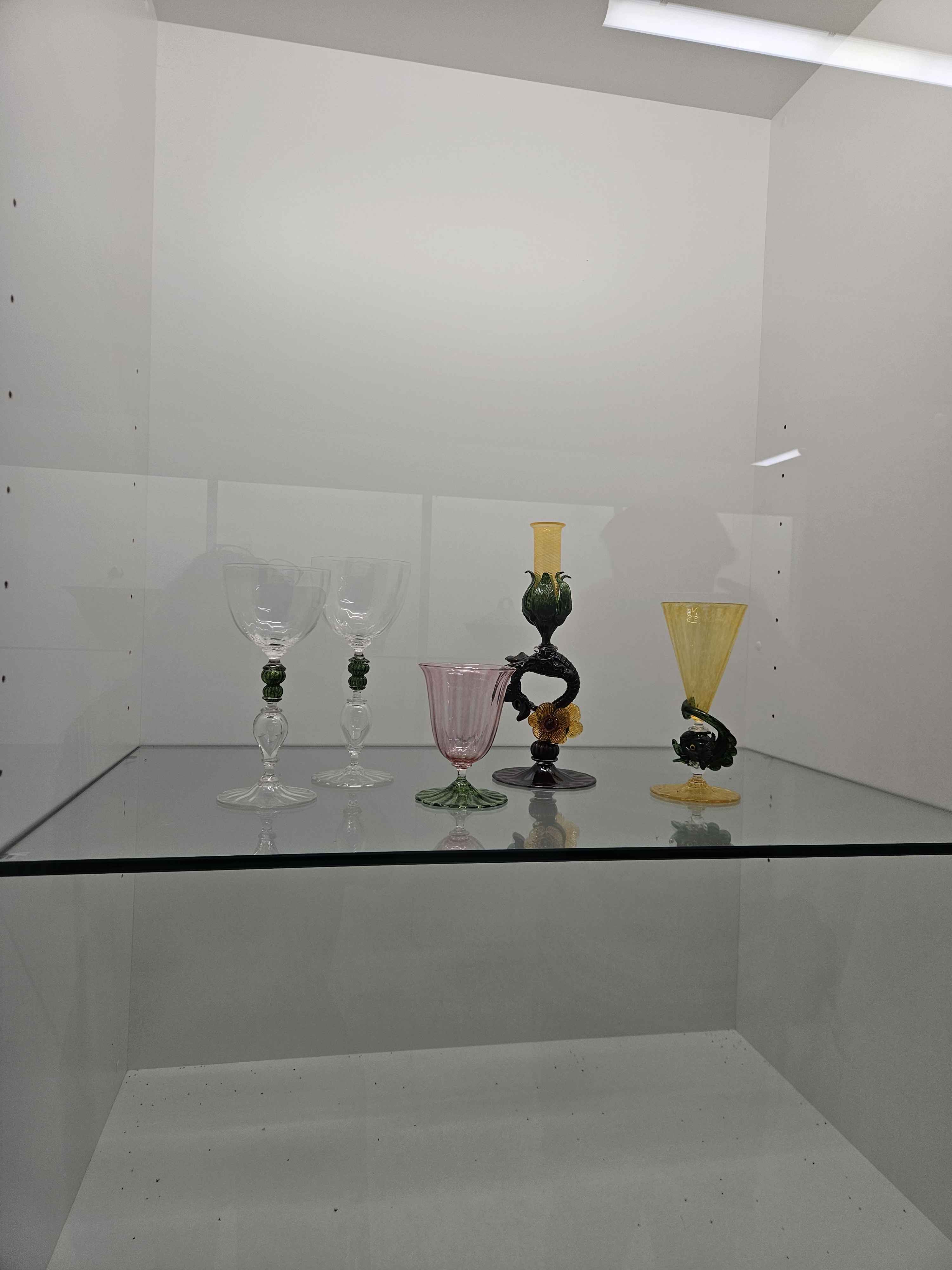 Glass is a material heavily used by the craft and design program (glass).
Glass is very brittle but very malleable when crafting with it. It is very fragile light-weight piece 
of material and can be used for drink consumption, holding items and being decorative items.  Working with liquid glass they will often focus more on the stability before moving forward with the artistic choices. The glass pieces shown in this image show a base which keeps the vases/artwork in place, then moving upward we see the how the glass is thrown to create visually stunning pieces.
 